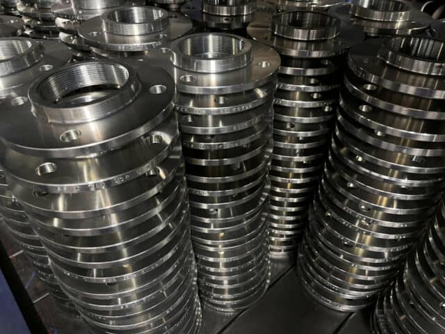 Image of stacks of steel flanges in our factory